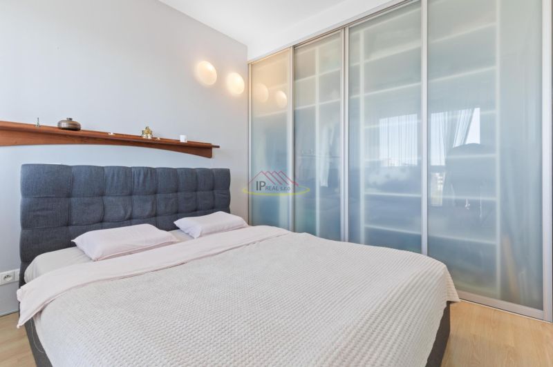Bedroom in a 2-room apartment with a sliding wardrobe and a wooden decor floor.