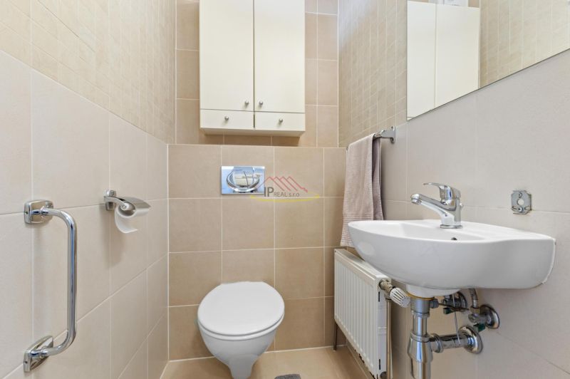 Bathroom in a 2-room apartment with a toilet, sink, and storage space.