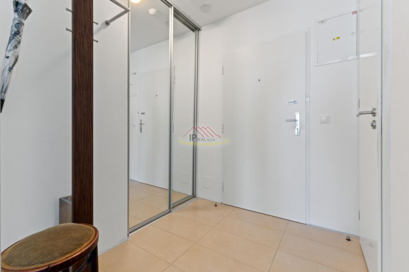 Entrance hall in a 2-room apartment with a large mirrored wardrobe and tiles.