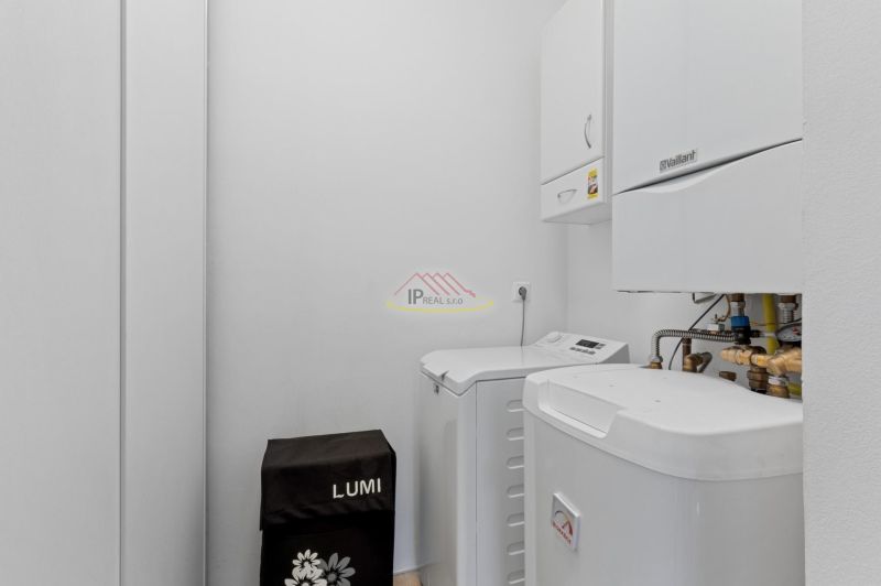 A technical room with a boiler and a washing machine in a 2-room apartment.
