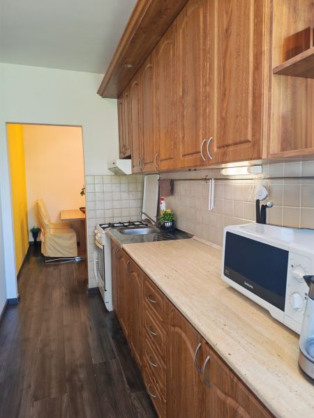 A kitchen with solid wood cabinets and a floor with a wood decor in a 3-room apartment.