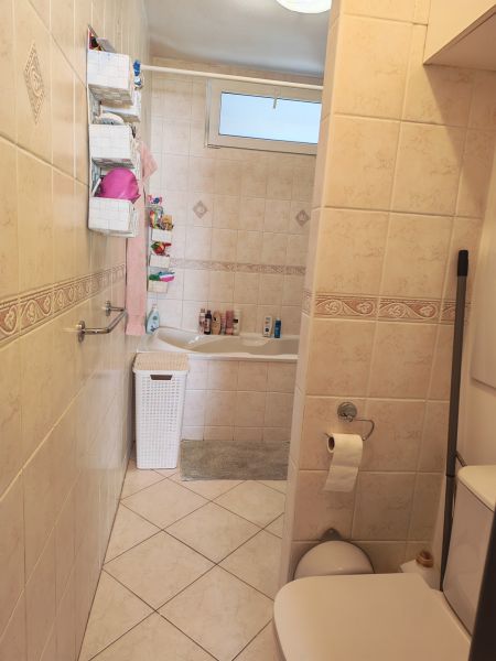 Bathroom with a bathtub and toilet in a 3-room apartment with tiles.