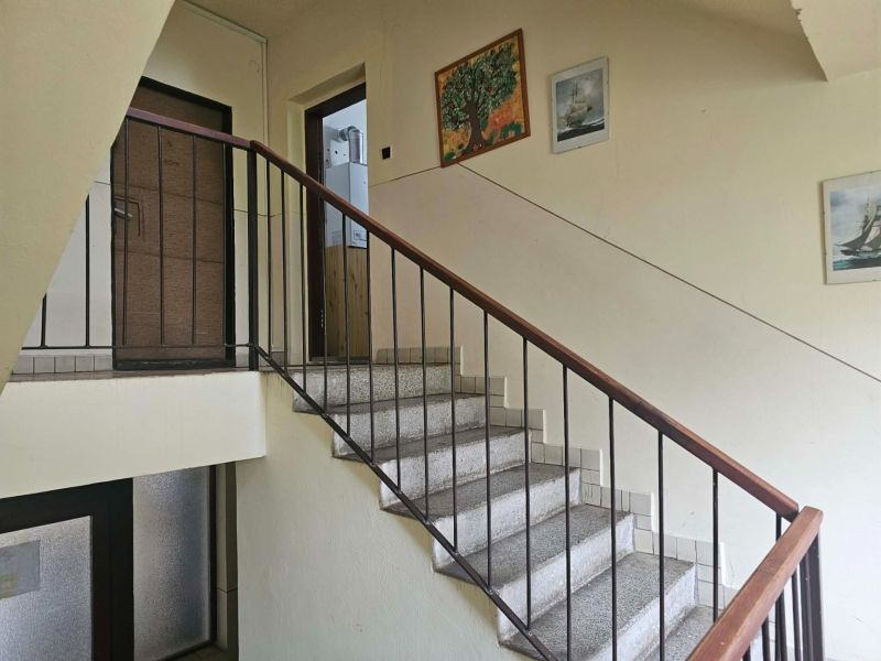 The staircase in the apartment building, leading to the door of a 3-room apartment, is adorned with paintings.
