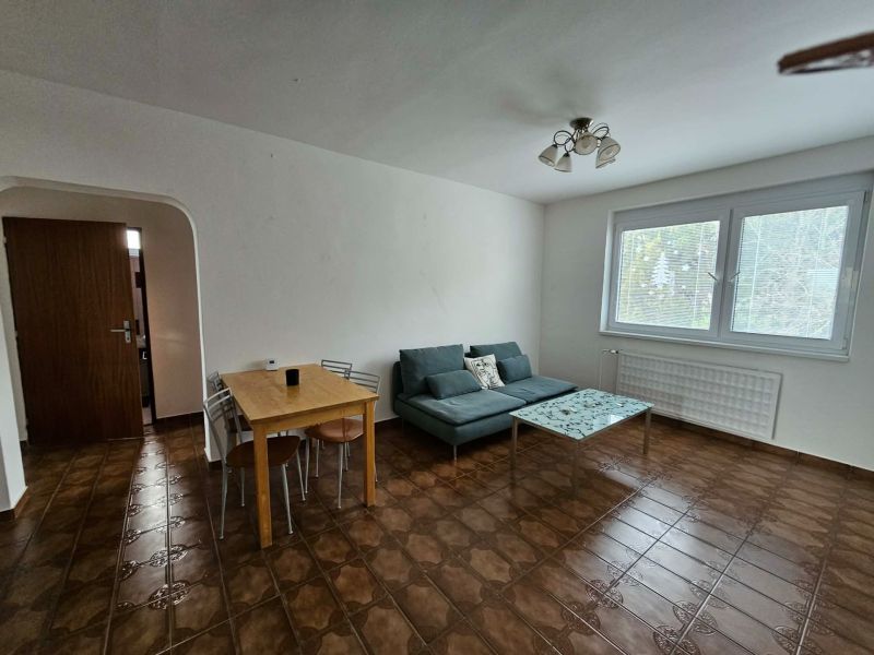 Living room in a 3-room apartment with tiles, a light sofa, and a table.