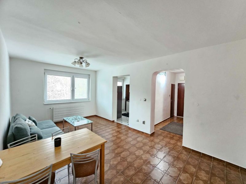 Living room with ceramic flooring and a sofa in a three-room apartment.