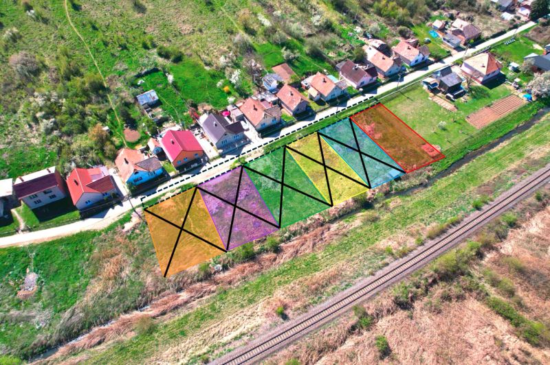 Aerial view of residential plots in Hodejov, houses, and a railway track.