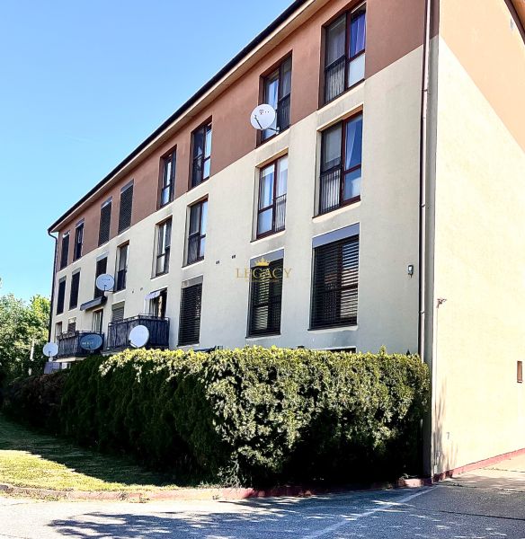 A building in Bernolákovo with 3-room apartments, satellites on the facade, green surroundings.
