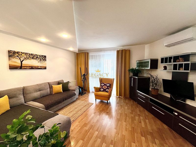 Living room in a 3-room apartment with a comfortable couch and a wooden decor floor.