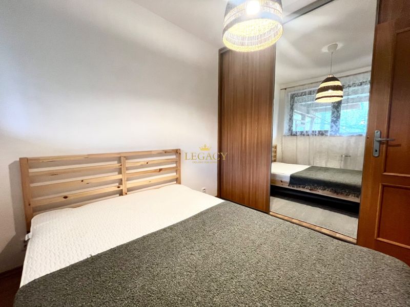 A bedroom in a 3-room apartment with a wooden bed and a built-in wardrobe.