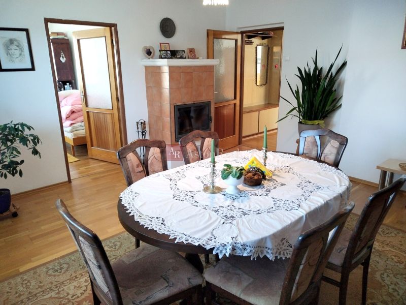 Dining room in a family house with a fireplace and a table with a lace tablecloth.