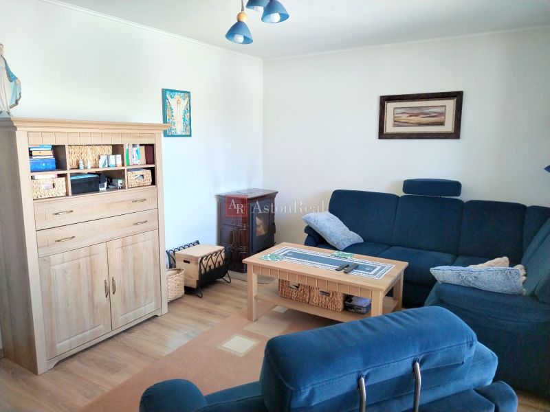 Living room in a family house with a blue sofa and a wooden decor floor.
