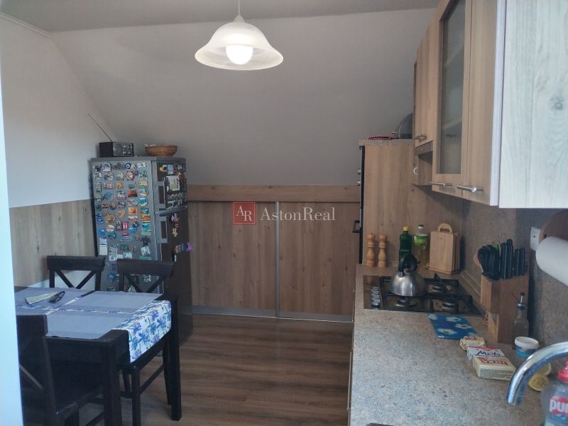 A kitchen in a family house with a dining table and a wooden decor floor.