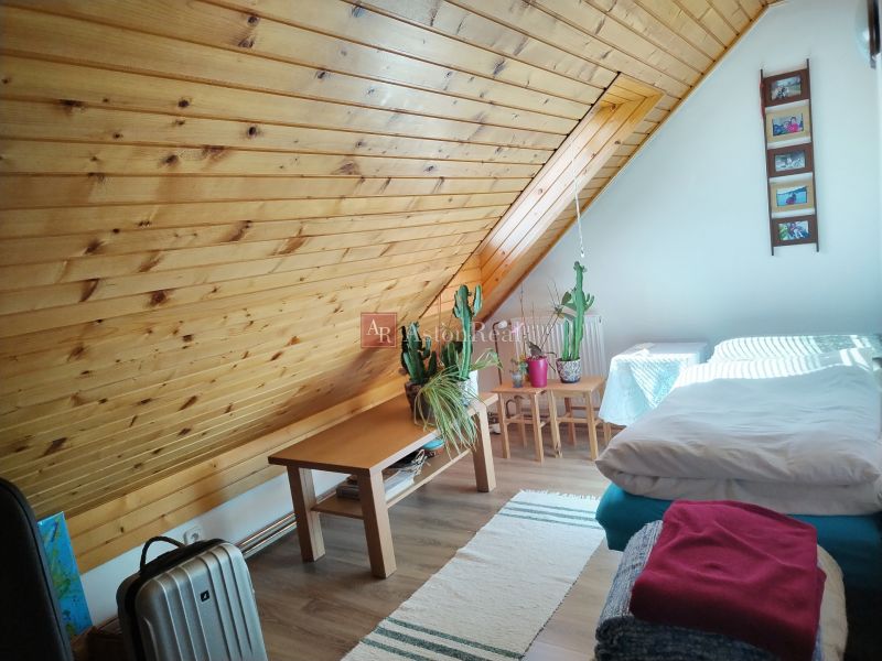 Attic room in a family house with wooden paneling and a floor with a wooden decor.