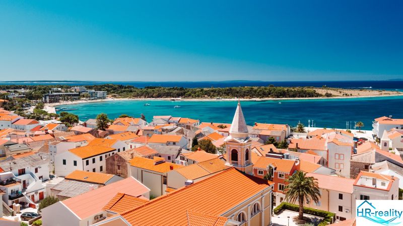 A view of the coastline and rooftops in Novalja, an ideal place for a 2-bedroom apartment.