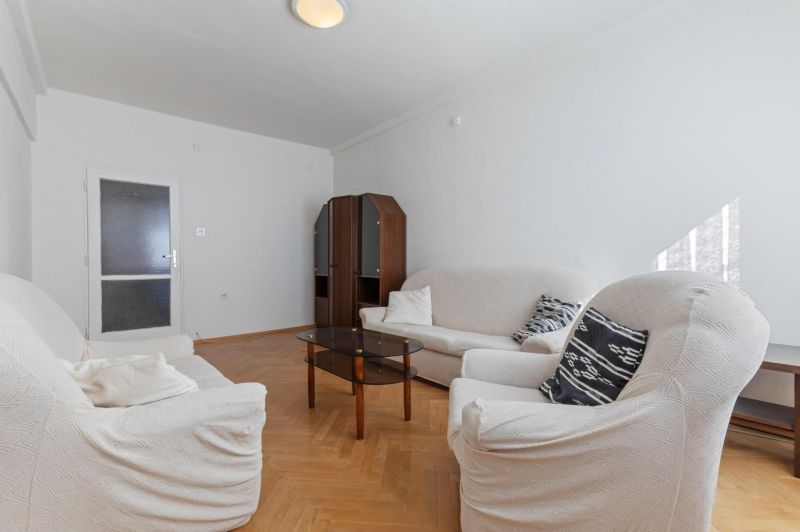 Living room with a sofa and a wooden decor floor in a 3-room apartment.