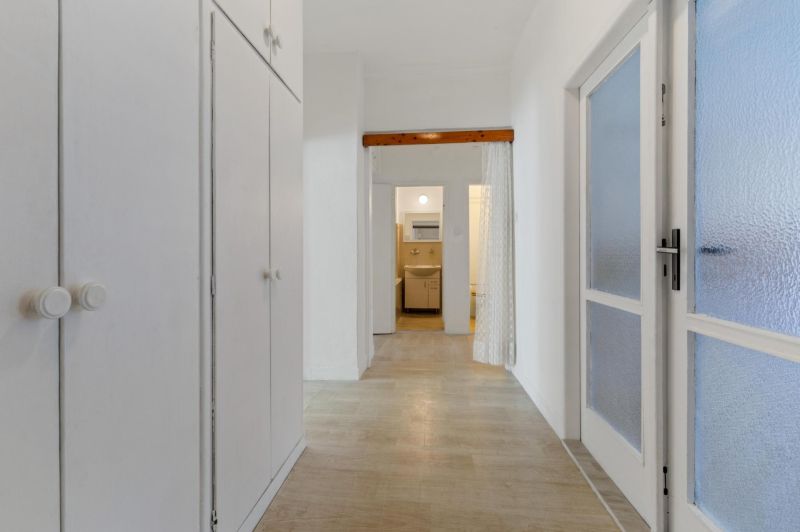 A hallway in a 3-room apartment with storage spaces and a floor with a wooden decor.