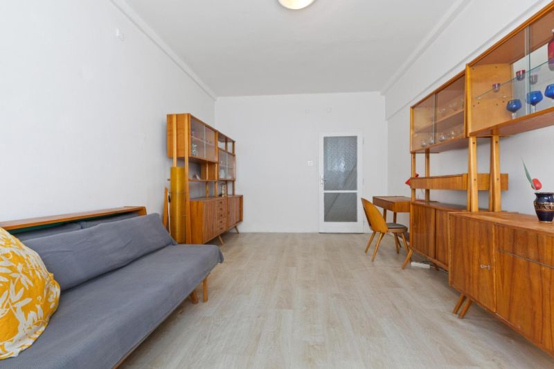 Interior of a 3-room apartment with retro furniture and wooden decor flooring.
