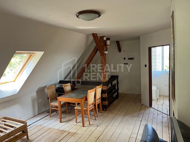 Interior of a family house with a dining table and chairs on a floor with a wooden decor.