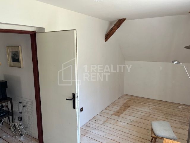 A room in a family house with a wooden decor floor and open doors.