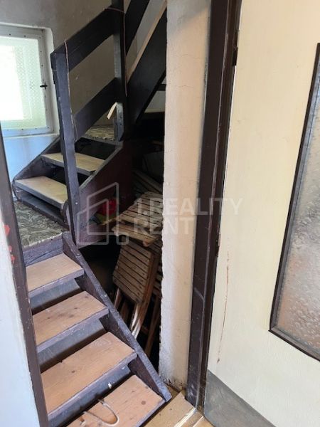 A staircase in a family house with storage space under the stairs, with glass doors.