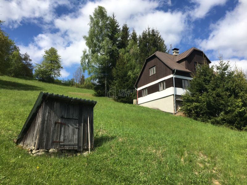 A family house in Korňa on Korňa Street surrounded by a green meadow and trees.