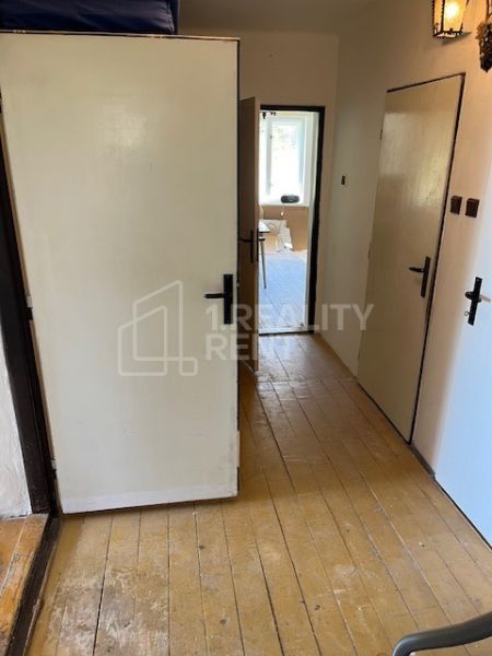 A hallway in a family house with a wooden floor and classic interior doors.