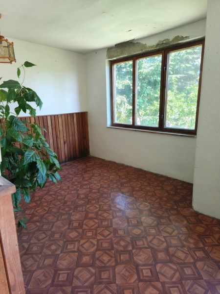 A room in a family house with a window and a wooden decor floor.