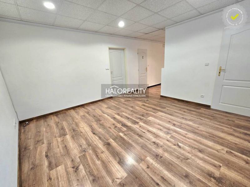 Spacious room with wooden decor flooring and shelves in a 3-room apartment.