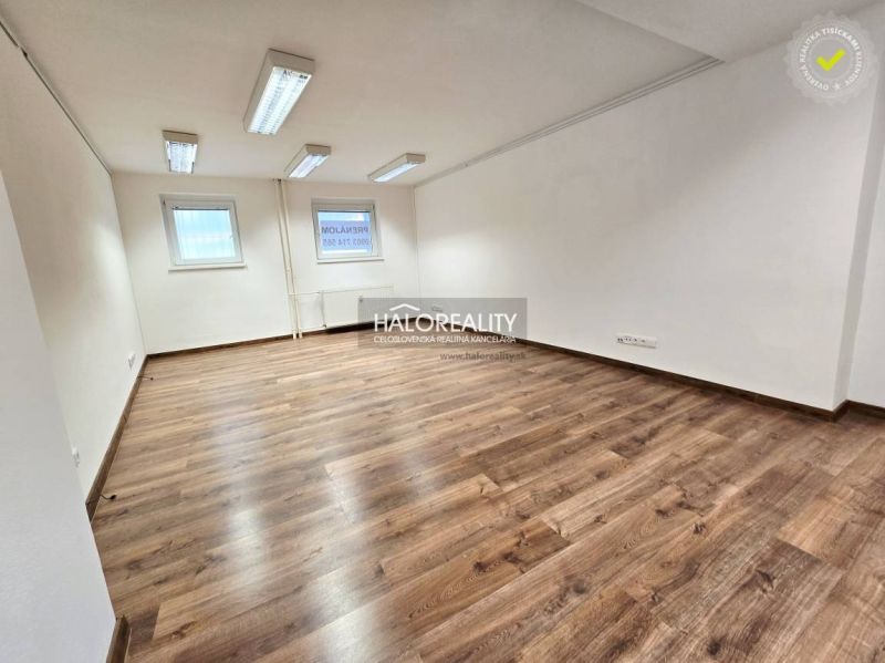 Spacious room in a 3-room apartment with wood-patterned flooring and white walls.