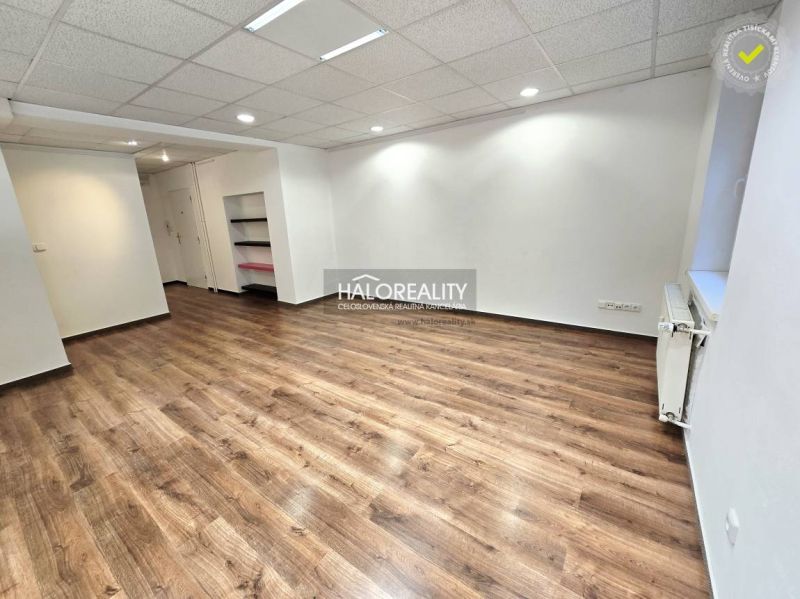 A room in a 3-bedroom apartment with a wooden-patterned floor and white walls.