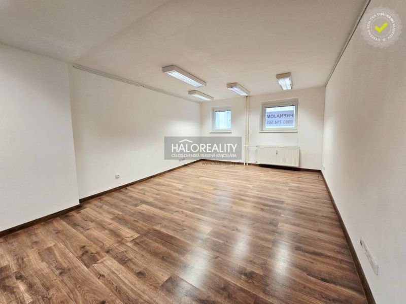 A white room in a 3-room apartment with wood-patterned flooring and a large window.