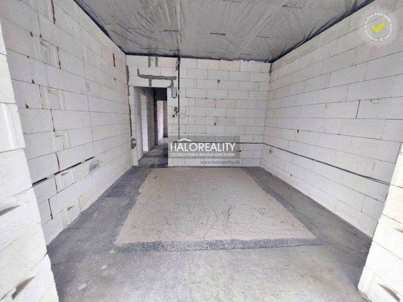Empty room with unplastered walls in a family house, concrete floor surface.