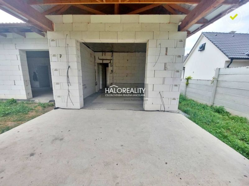 Concrete terrace at a family house in Rybník with an unfinished interior and lawn.