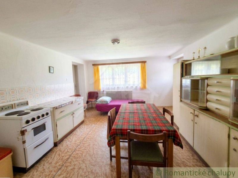 Interior of a family house with a kitchen unit and a dining table, floor with wooden decor.