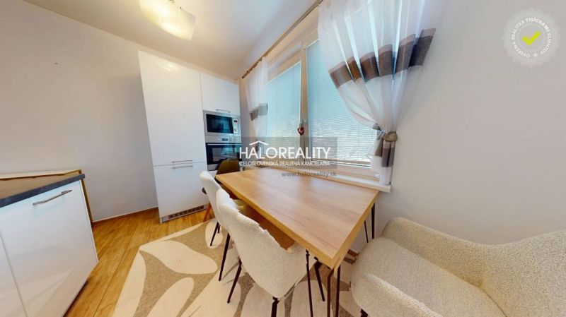 A kitchen in a 2-room apartment with a wooden decor floor and natural lighting.