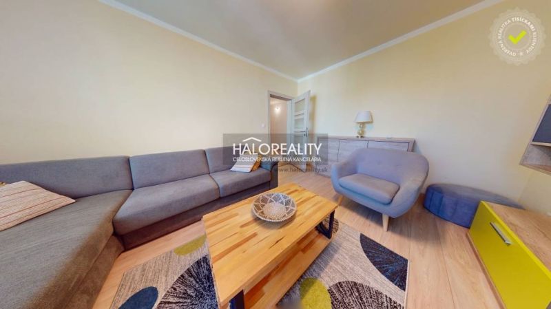 Living room in a two-room apartment with a large sofa and a coffee table.