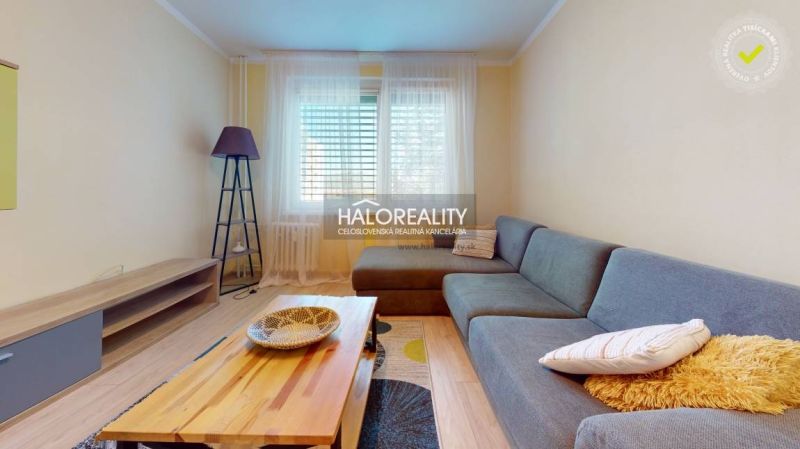 Living room in a two-room apartment with a corner sofa and a floor with a wooden decor.