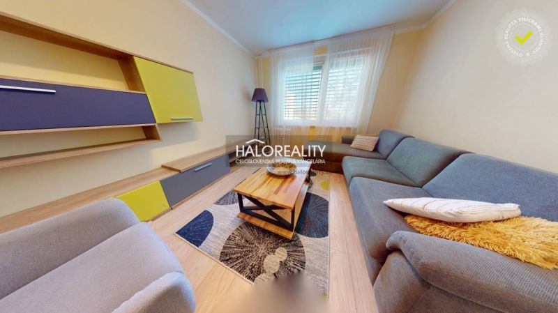 Living room in a two-room apartment with a wooden decor floor and a colorful set.