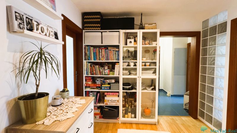 3-room apartment with shelves for books, games, and dishes, wooden floor decor.