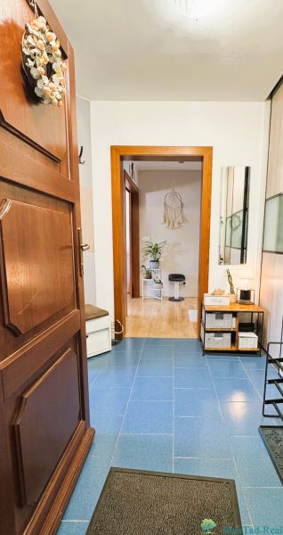 Entrance hall in a 3-room apartment with tiled floor, decor, and furniture.