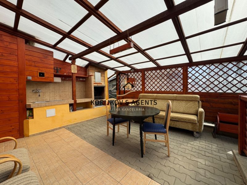 Covered terrace with seating and grill at the cottage in Svinica.