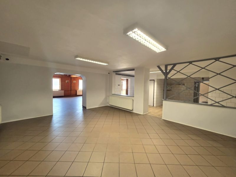 A space with tiled flooring, white walls, and lighting suitable for gastronomic use.
