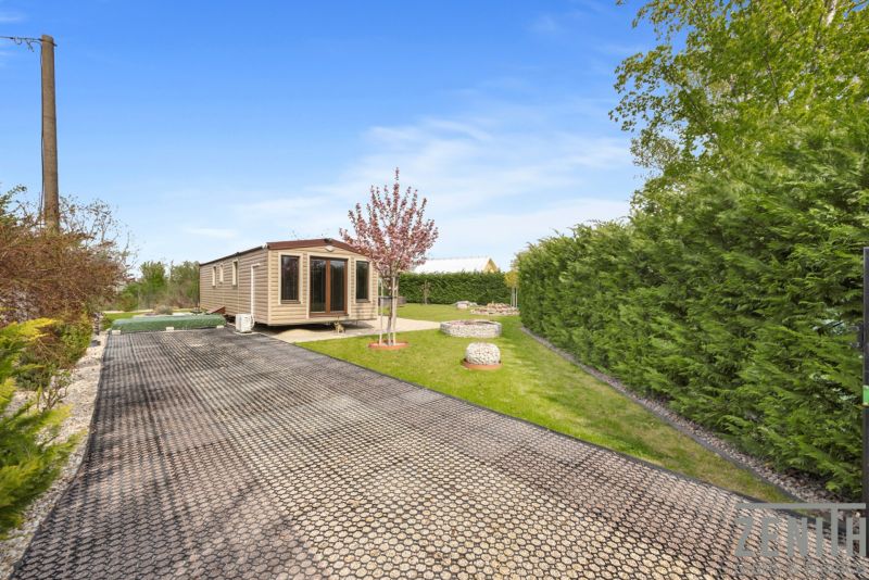 Cottage in Hurbanovo with a garden, paved path, and ornamental stones.