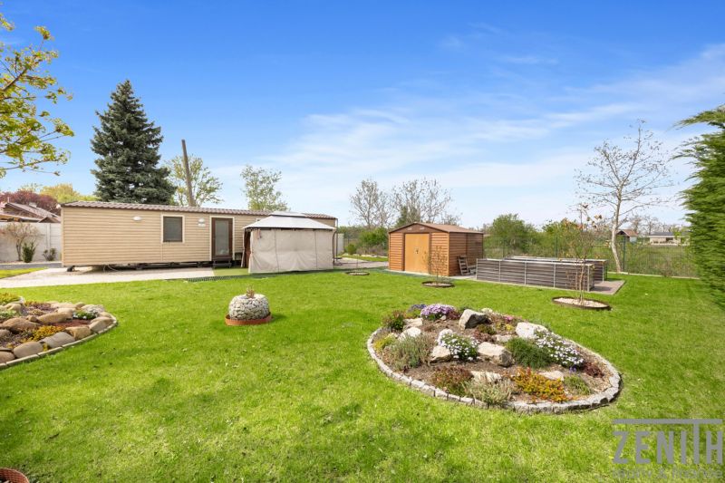 A landscaped garden with a mobile home, gazebo, and storage space in Hurbanovo.
