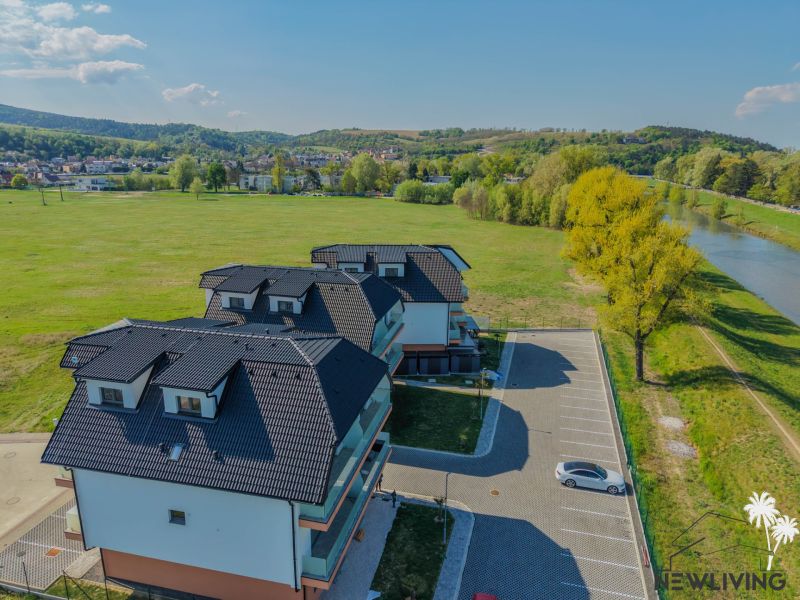 New buildings by the river on Moravanská Street in Banka with parking spaces.