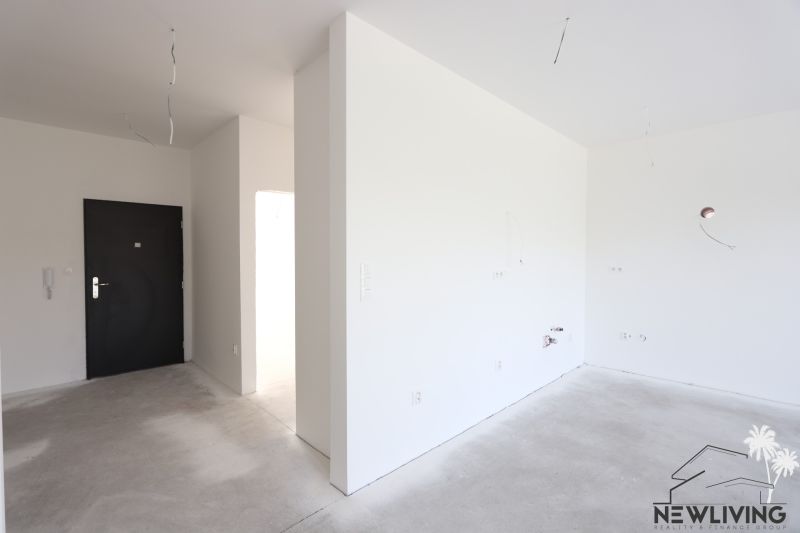 The entrance leads to a 2-room apartment with white walls and a concrete floor.