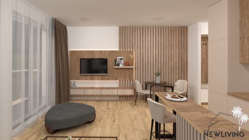 Living room in a two-room apartment with a TV on the wall, wooden decor flooring.