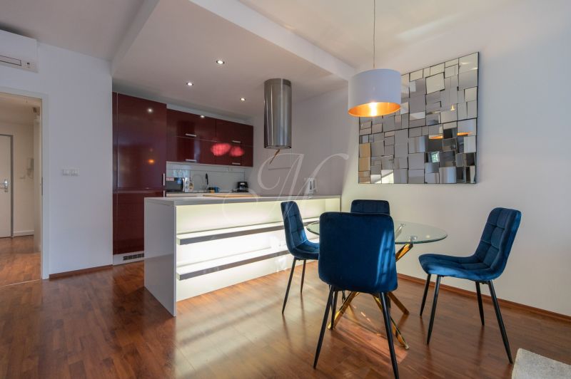 A stylish kitchen with wood-effect flooring in a 2-room apartment.