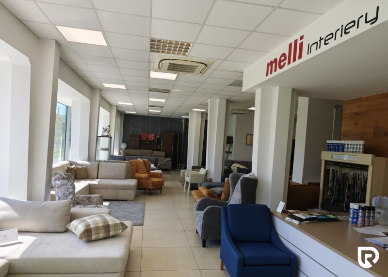 Interior of commercial spaces with displayed furniture, sofas, and armchairs.