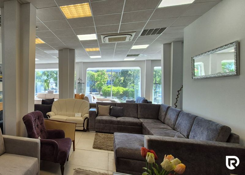 Interior of commercial spaces with sofas and armchairs on a floor with wooden decor.